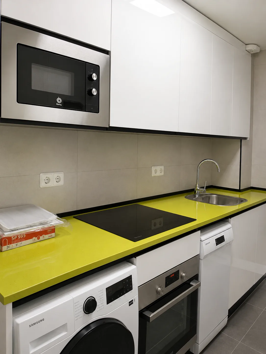 Cocina blanca con encimera amarilla instalada a medida